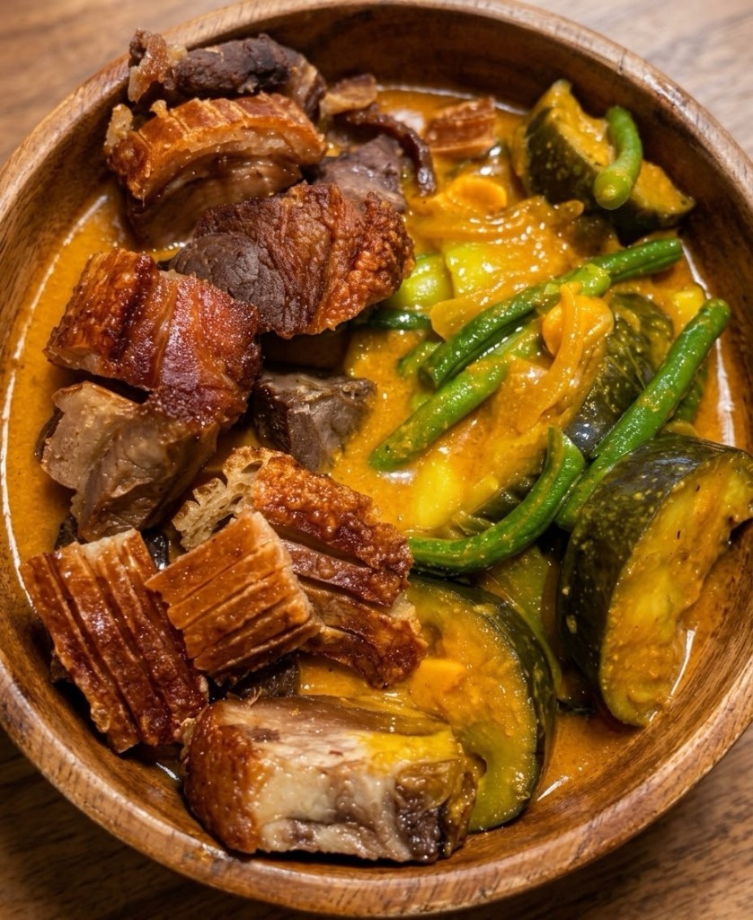 Crispy pork kare-kare in a wooden bowl