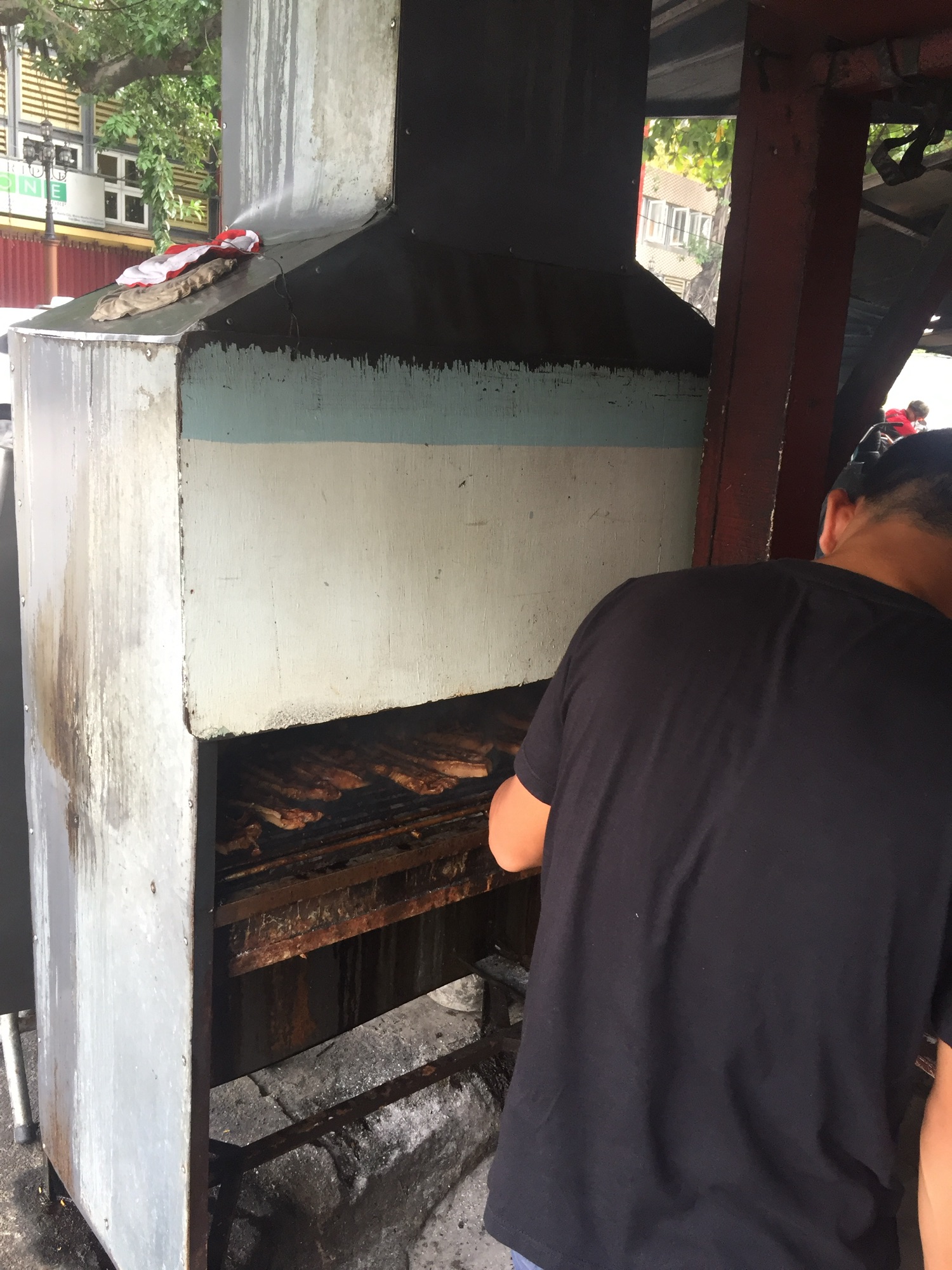 The grill box at Sosing's Carinderia with liempo cooking over charcoal